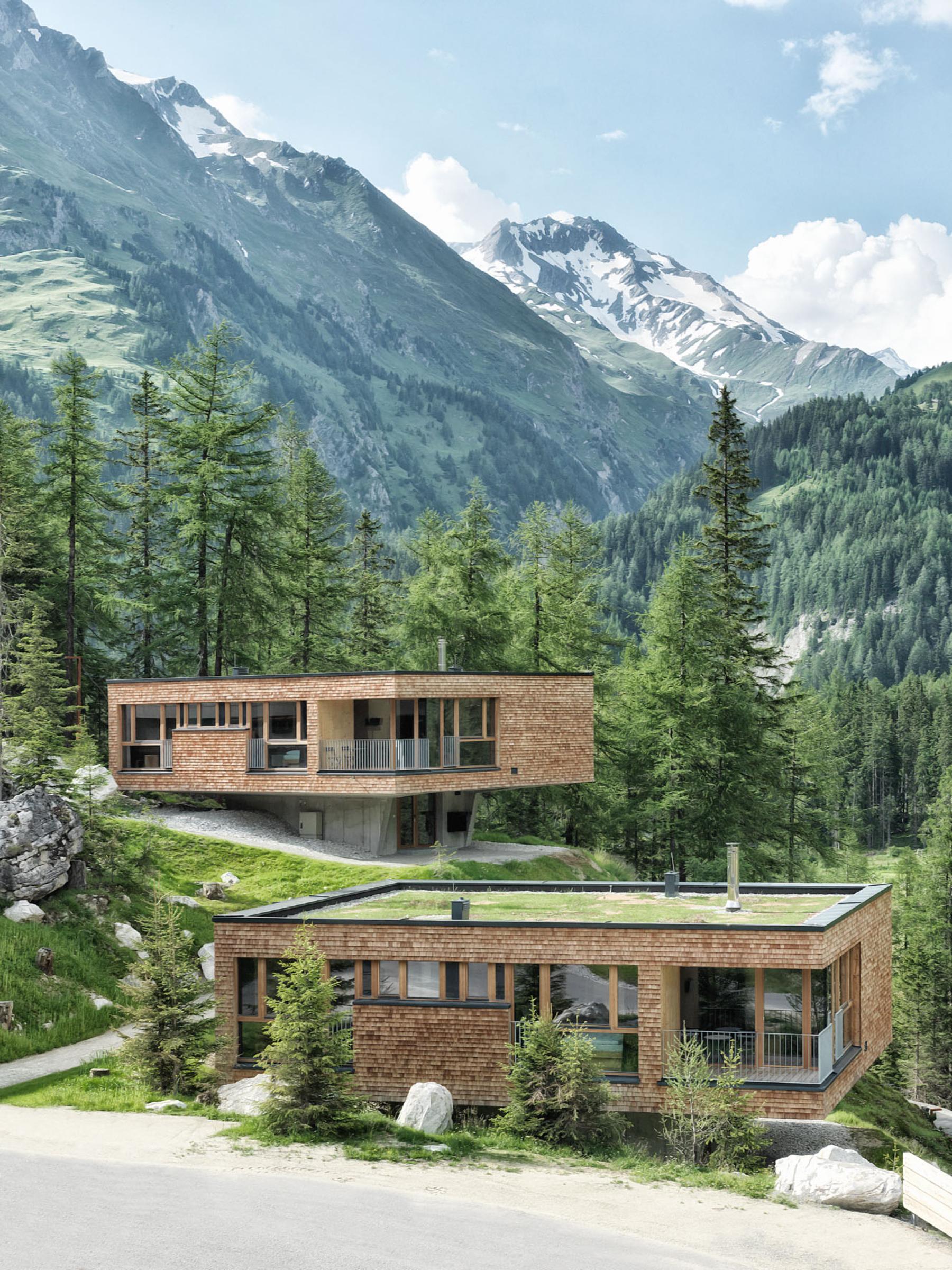 Hotel Gradonna Chalets mit Schindeln, dahinter die Berge Osttirols