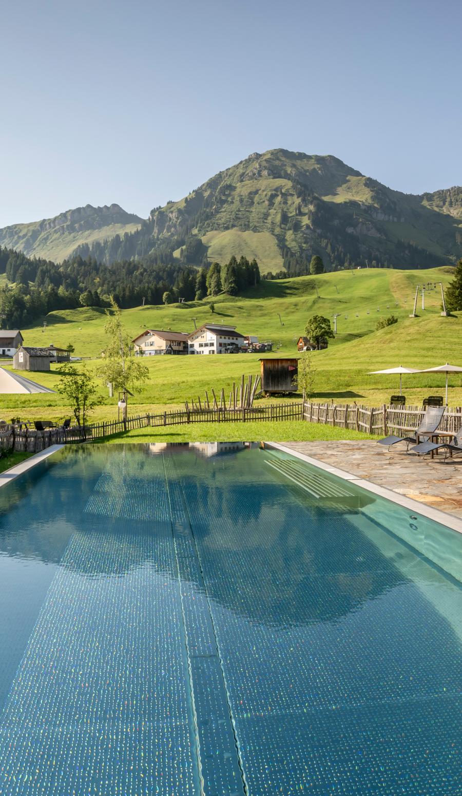 Change Maker Hotel Fuchsegg Eco Lodge mit Pool im Sommer