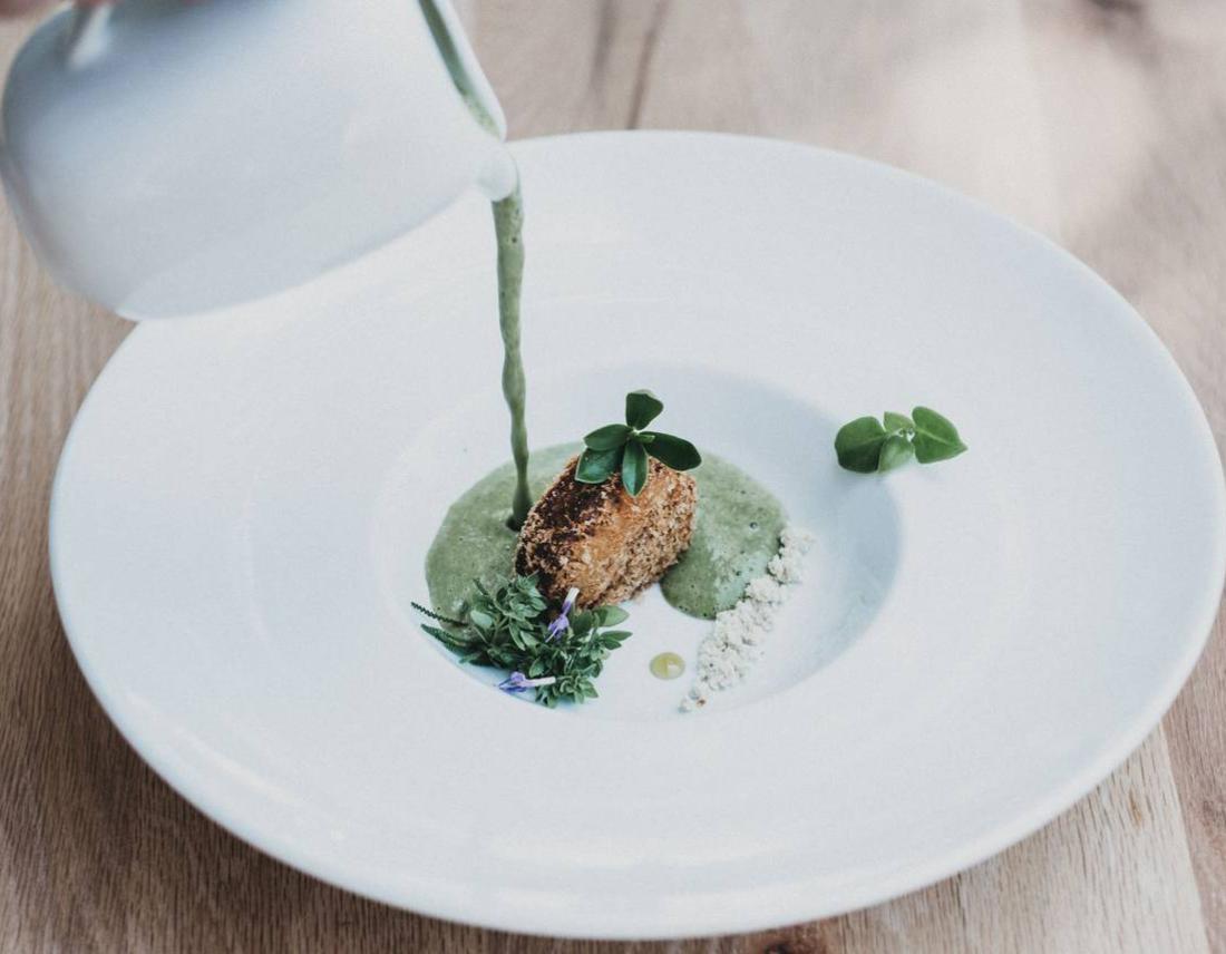 Gericht mit grüner Soße auf einem weißen Teller