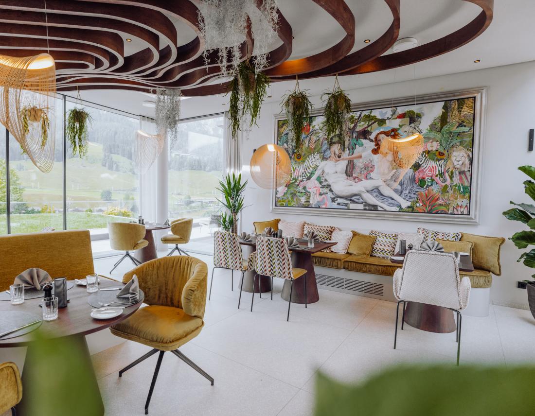 Design Restaurant mit vielen Pflanzen und Blick auf die Berge