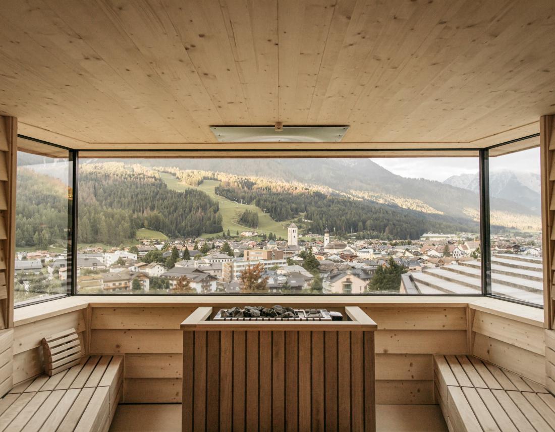Große Holzsauna mit zwei Holzbänken und Panoramafenster