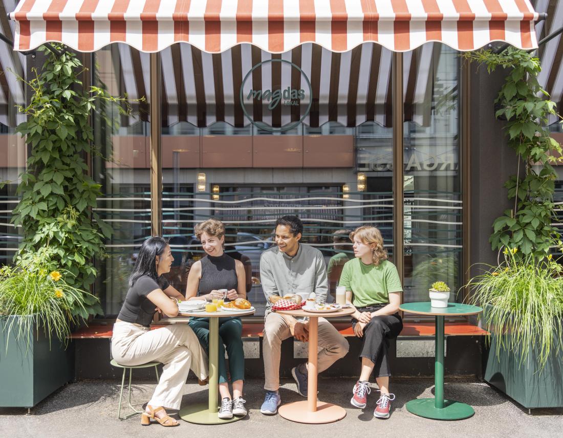 4 Menschen im Schanigarten vom Change Maker Hotel Magdas in Wien