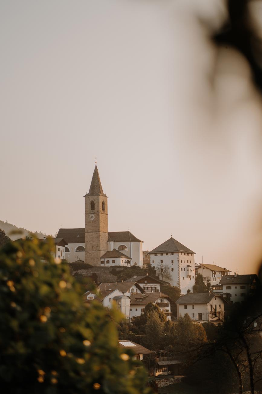 Blick auf ein kleines Dorf mit Kirchturm im Sonnenuntergang