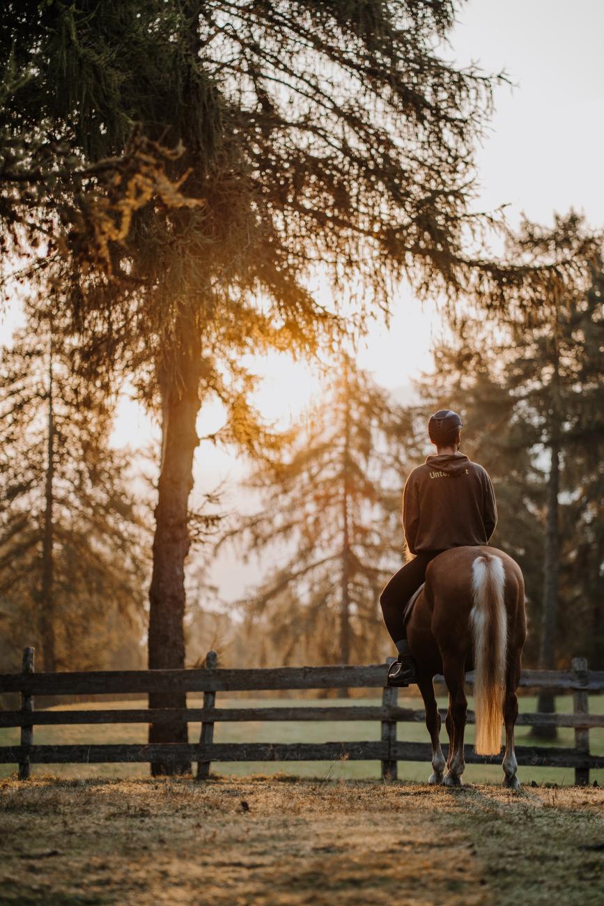 Frau auf einem Pferd im Sonnenuntergang