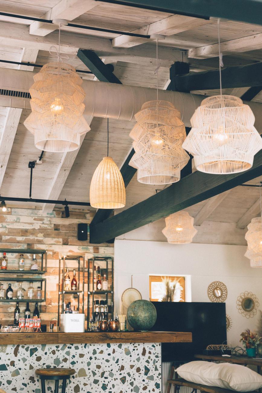 Bar mit Threse und weißen Lampen, die von der Decke hängen