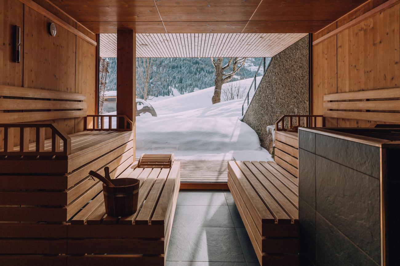 Sauna mit großem Panoramafenster mit Blick auf verschneite Landschaft