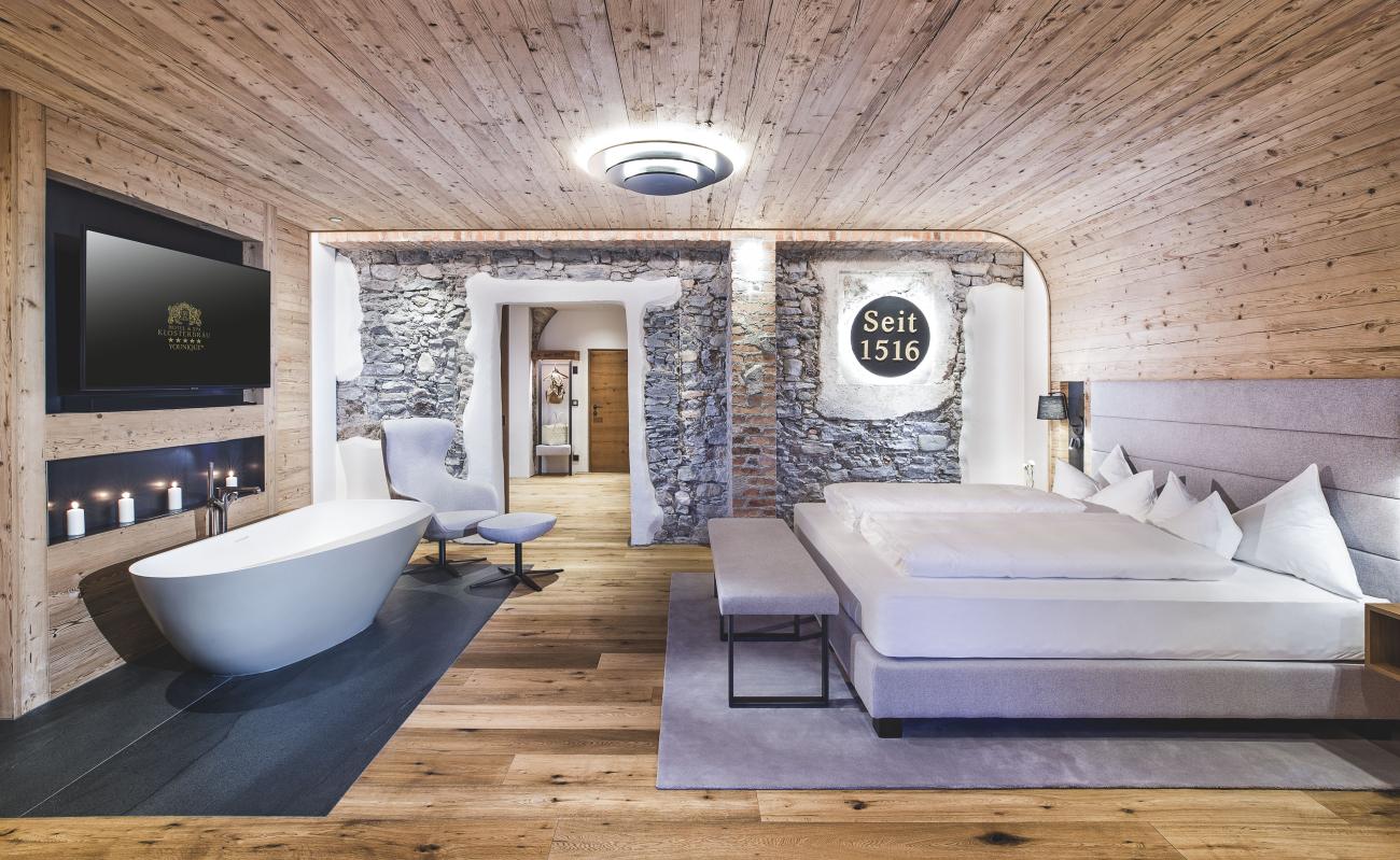 Suite mit Doppelbett, freihstehender Wanne und Holzwänden