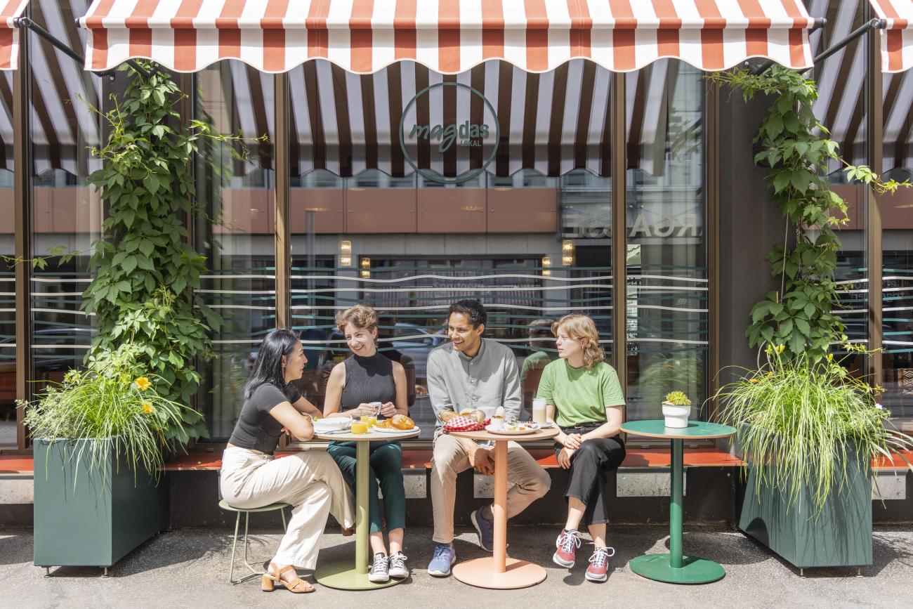 4 Menschen im Schanigarten vom Change Maker Hotel Magdas in Wien