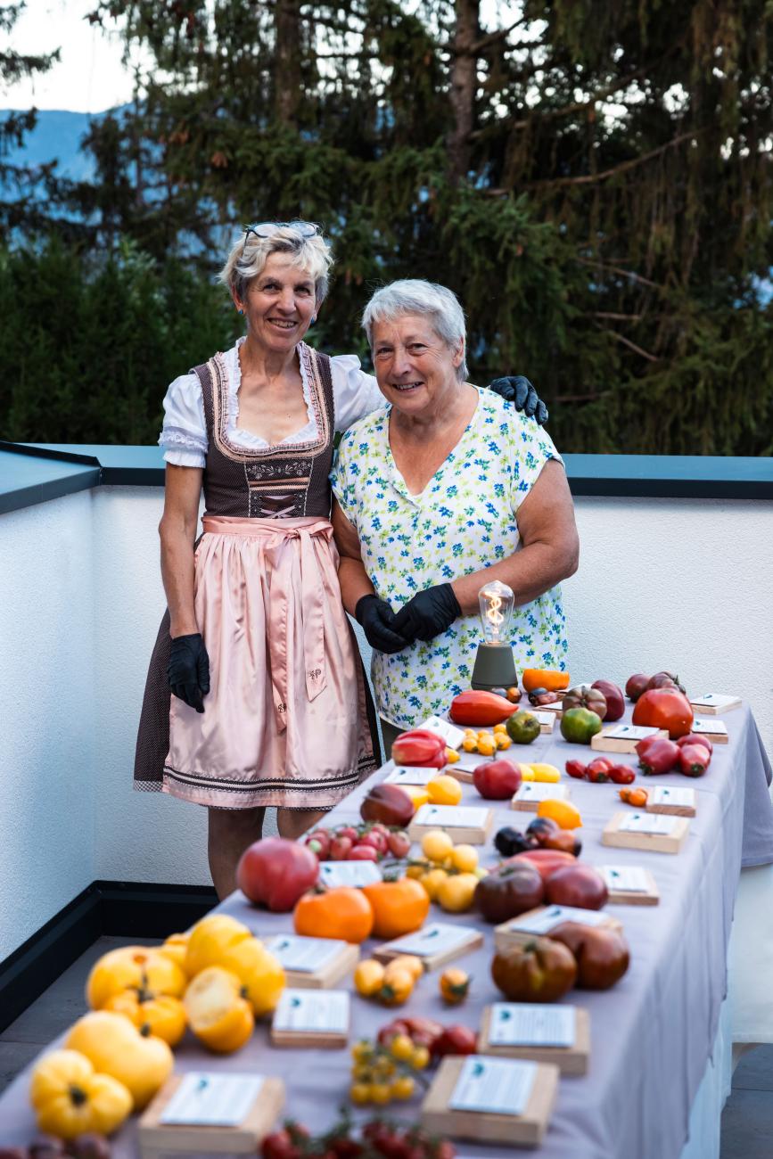 Zwei Frauen, die vor einem Tisch voller Gemüse stehen