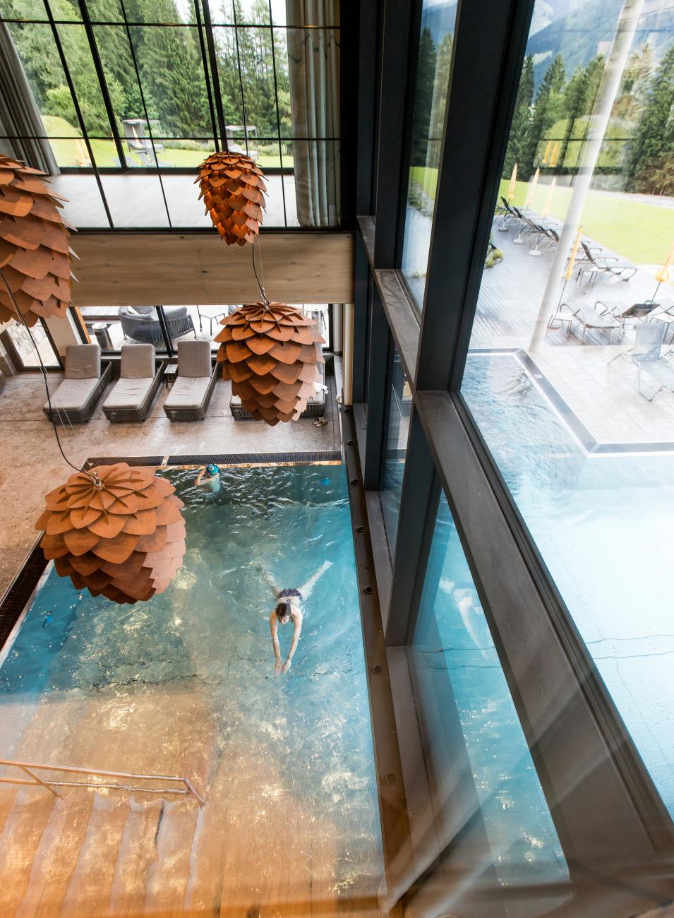 Indoor pool in dem ein Mensch schwimmt von oben