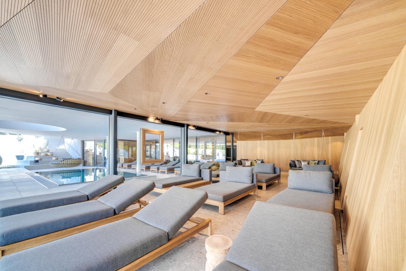 Raum mit Holzwänden und grauen Liegen im Hintergrund ist ein Indoor Pool