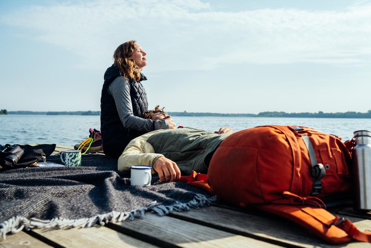  Couple taking a break after hiking on nature park trail_2
