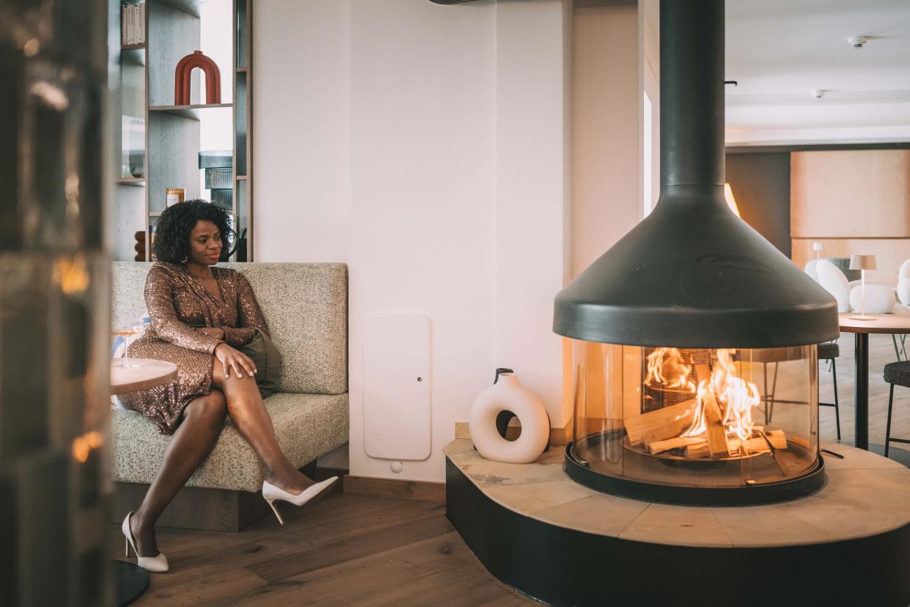 Frau sitzt am Kamin in Lounge