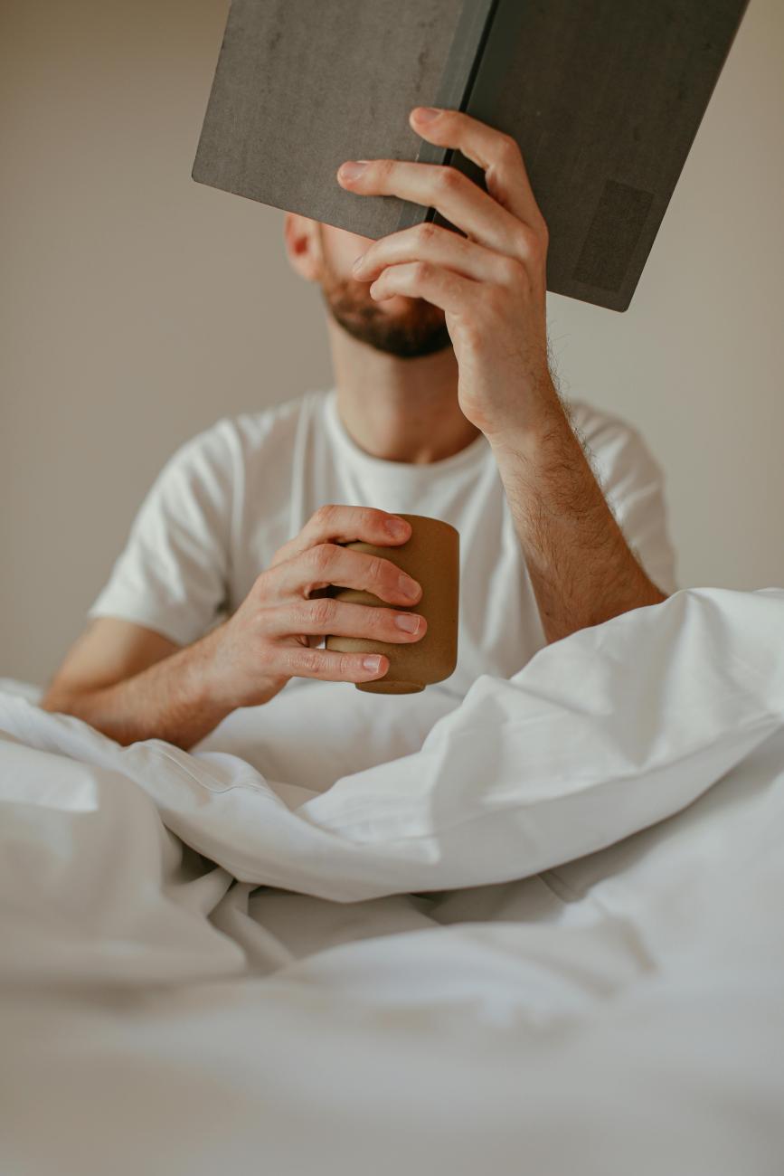 Mann liest Buch im Bett