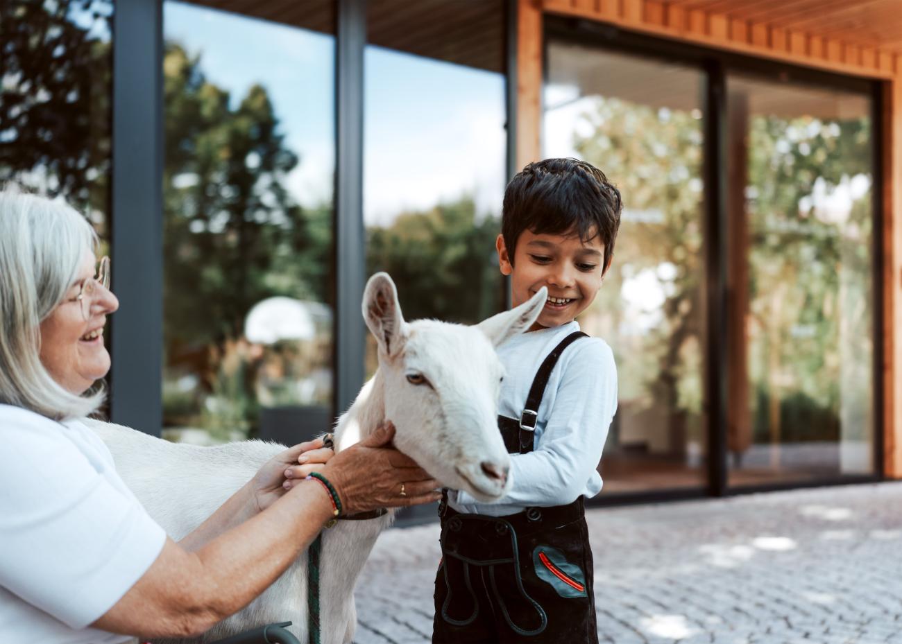 Kind mit Ziege vor dem Hotel Stern