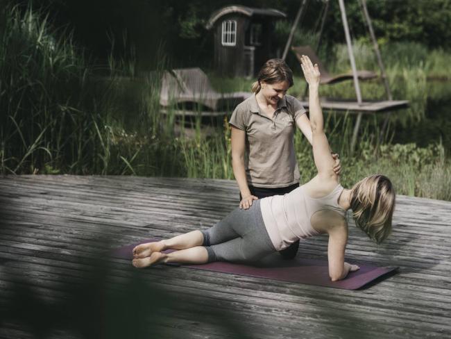 Zwei Frauen beim Yoga auf einem Steg