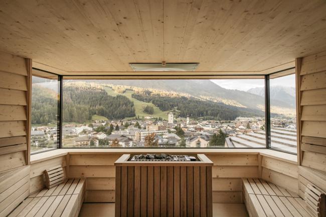 Große Holzsauna mit zwei Holzbänken und Panoramafenster