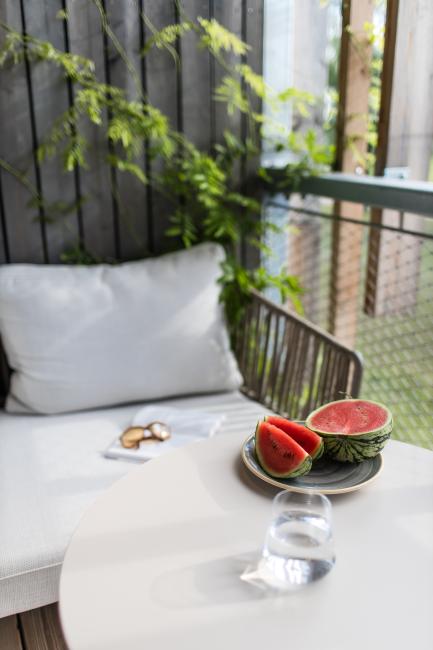 Sitzbereich auf einem Balkon mit einem Teller, auf dem eine Wassermelone liegt