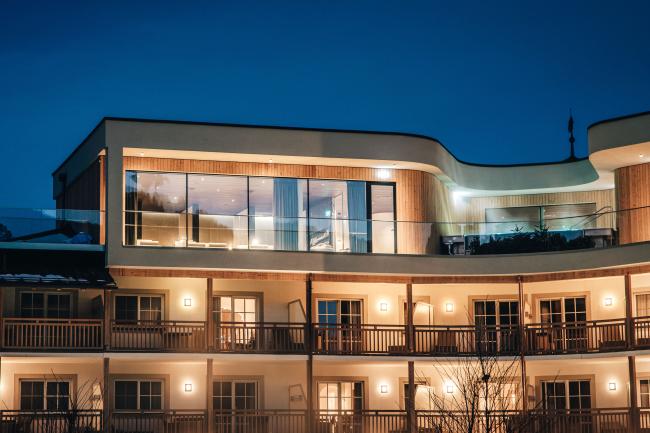 Dreistöckige Hausfassade mit Balkonen bei Nacht