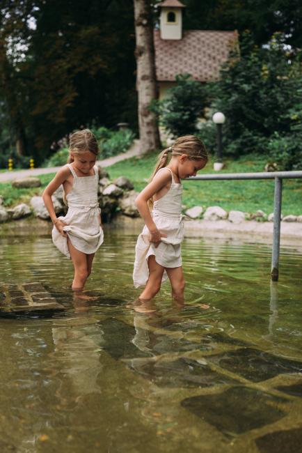 Zwei Mädchen, die durch ein kleinen Teich gehen