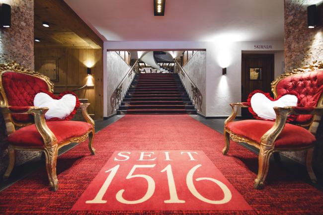 Hotelhalle mit rotem Teppich und zwei rot-goldenen Sesseln