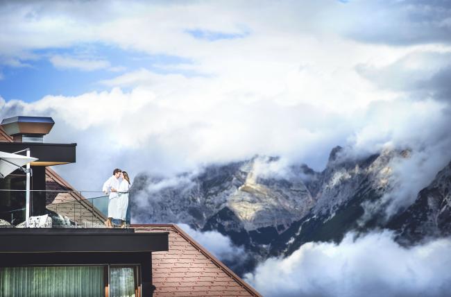 Mann und Frau auf einem Balkon mit Bergblick