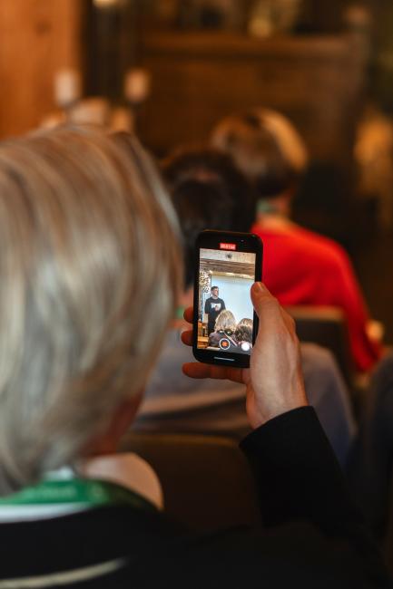 Gast macht ein Video vom Vortrag. 