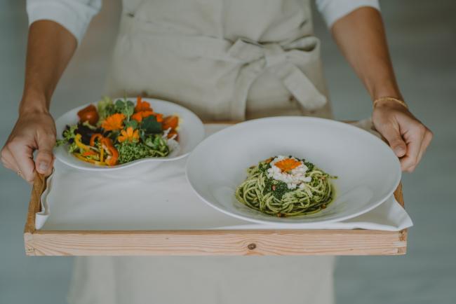 Kellner mit zwei Gemüsetellern am Tablett