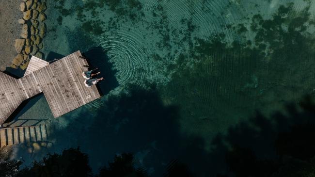 Paar sitzt am See-Steg vom Biohotel Daberer