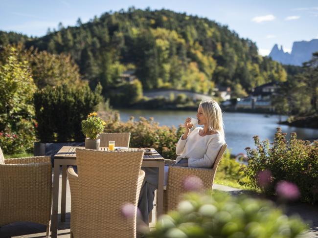 Frau genießt Frühstück mit Blick auf See im Weihrerhof