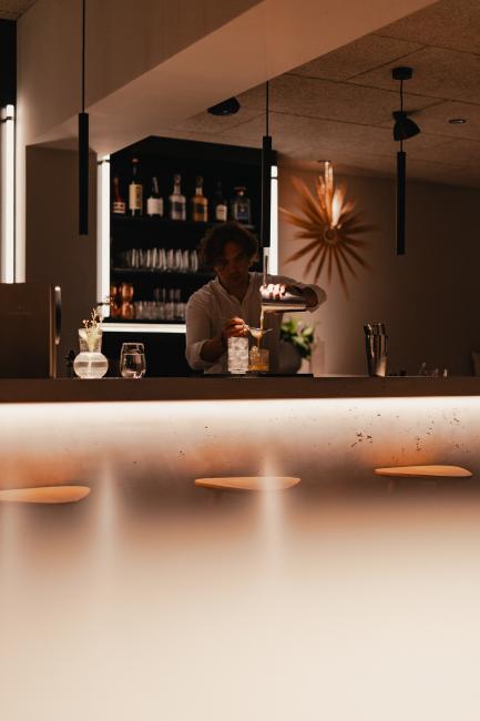 Barkeeper mixt einen Drink im Haus Jausern