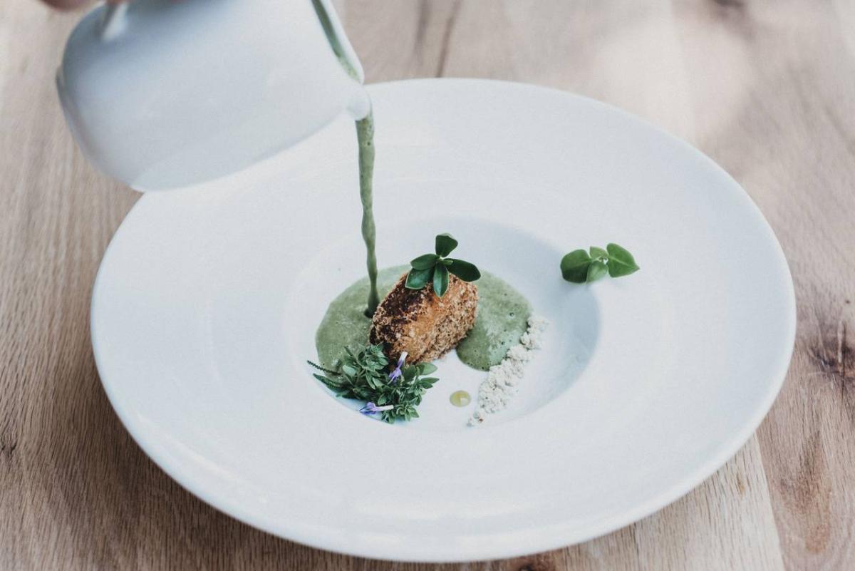 Gericht mit grüner Soße auf einem weißen Teller